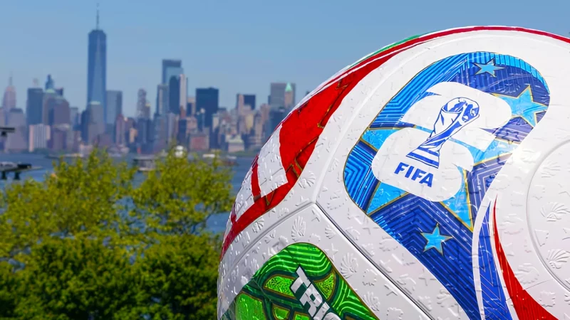 Soccer Football with FIFA logos pictured in front of a skyline of skyscrapers in the distance